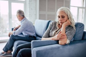 Man and wife sitting on couch, not talking to each other, angry or upset