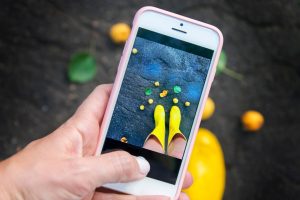 Person taking a photo of their yellow rainboots against a fall backdrop