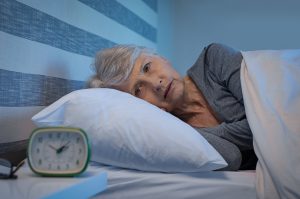 Older woman laying awake in bed in the middle of the night