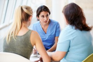 Two women talking to hospice nurse