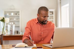 Middle-aged man sitting at computer in his bright, clean home