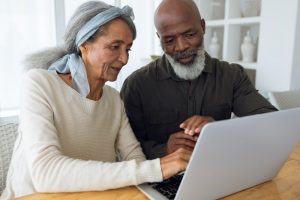 Man and woman sitting at table, working at computer