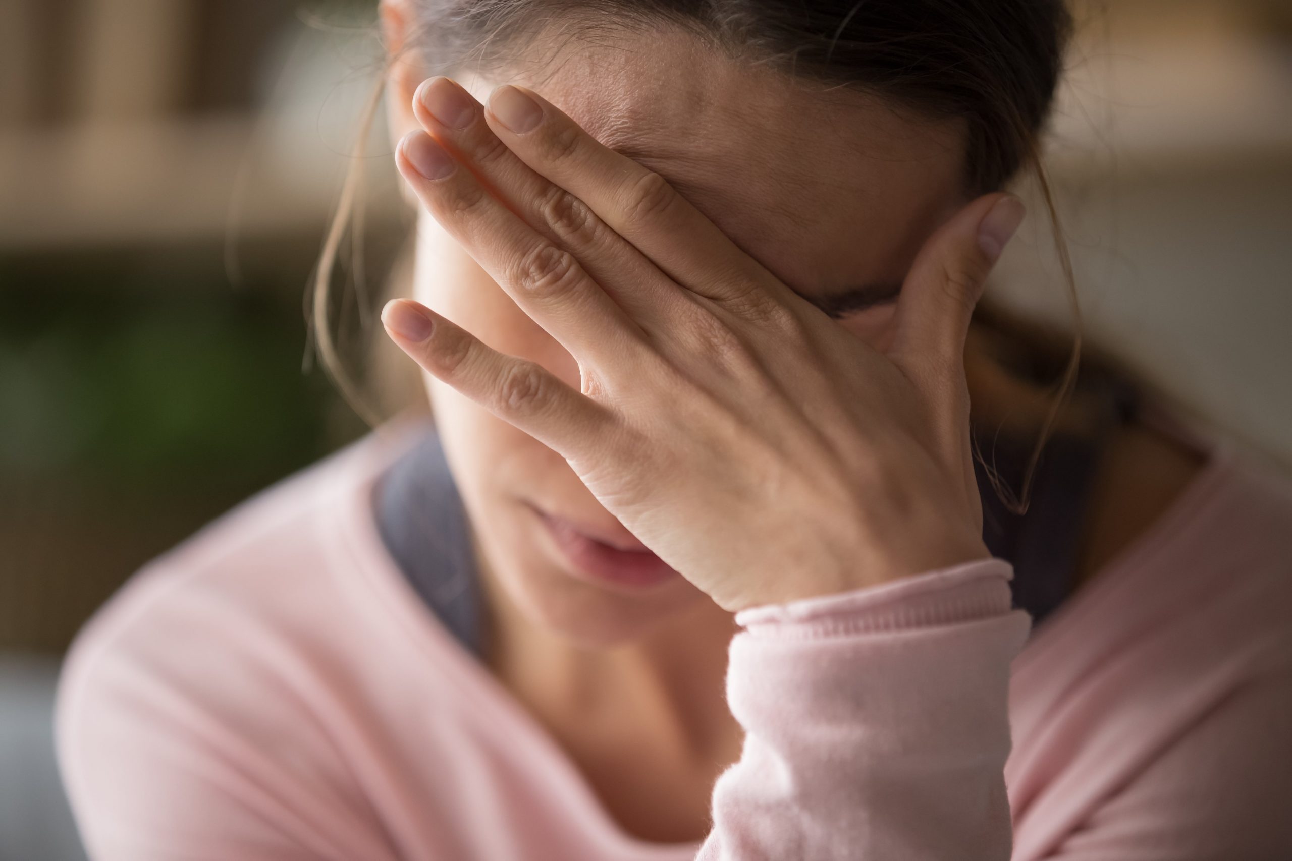 Upset young woman sitting alone, putting hand on palm