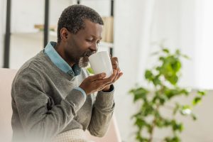 Content man drinking a hot cup of coffee