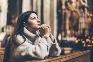 Woman praying in a religious building