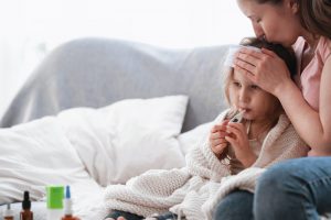 Mom kissing her sick daughter's head