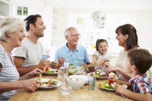 Family of 4 with grandparents sharing a meal together at home