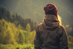 Woman standing outside in fall, contemplating and thinking