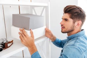 Young man putting away memory capsule box until determined date