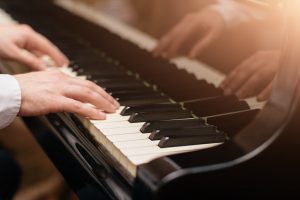 Person playing piano, focus on hands