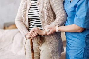 At home nurse helping a woman walk