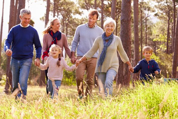 Grandparents, parents, and two kids wallking outside together and enjoying time