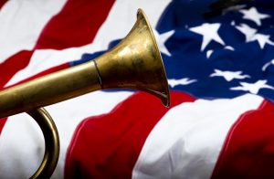 Majority of bugle visible against the backdrop of an American flag