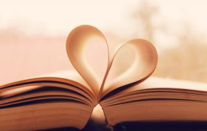 Open book with pages folded together in middle to create a heart