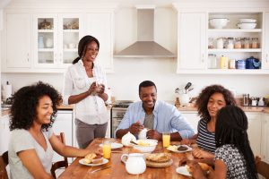 Blended family of 5 sitting at breakfast table, eating a meal together