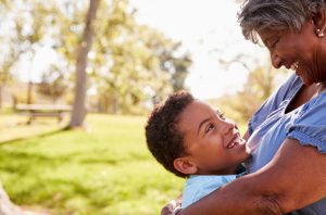 Grandmother hugging grandson, both smiling