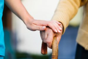 With a caring hand, shows how a nurse looks after an elderly patient