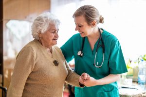 nurse walking with older woman