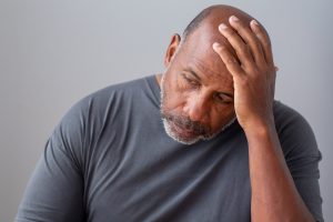stressed older man with hand on head