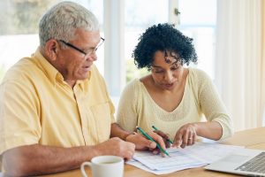 Husband and wife sitting at kitchen table working on estate planning