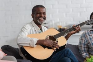 smiling man playing guitar