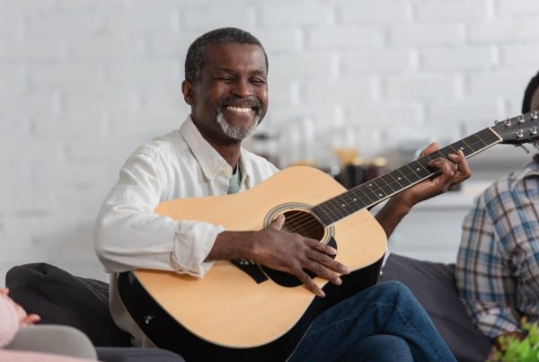 smiling man playing guitar