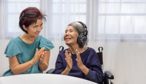 music therapist helping a woman in hospice wearing headphones