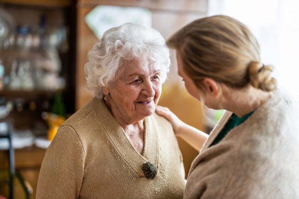 older woman smiling while talking to a volunteer