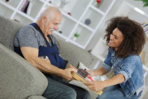 Young female hospice volunteer bringing an older injured man food