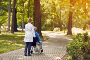 Hospice nurse pushing man in wheelchair