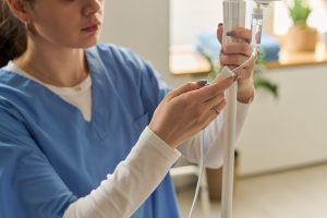 Hospice worker setting up an IV drip